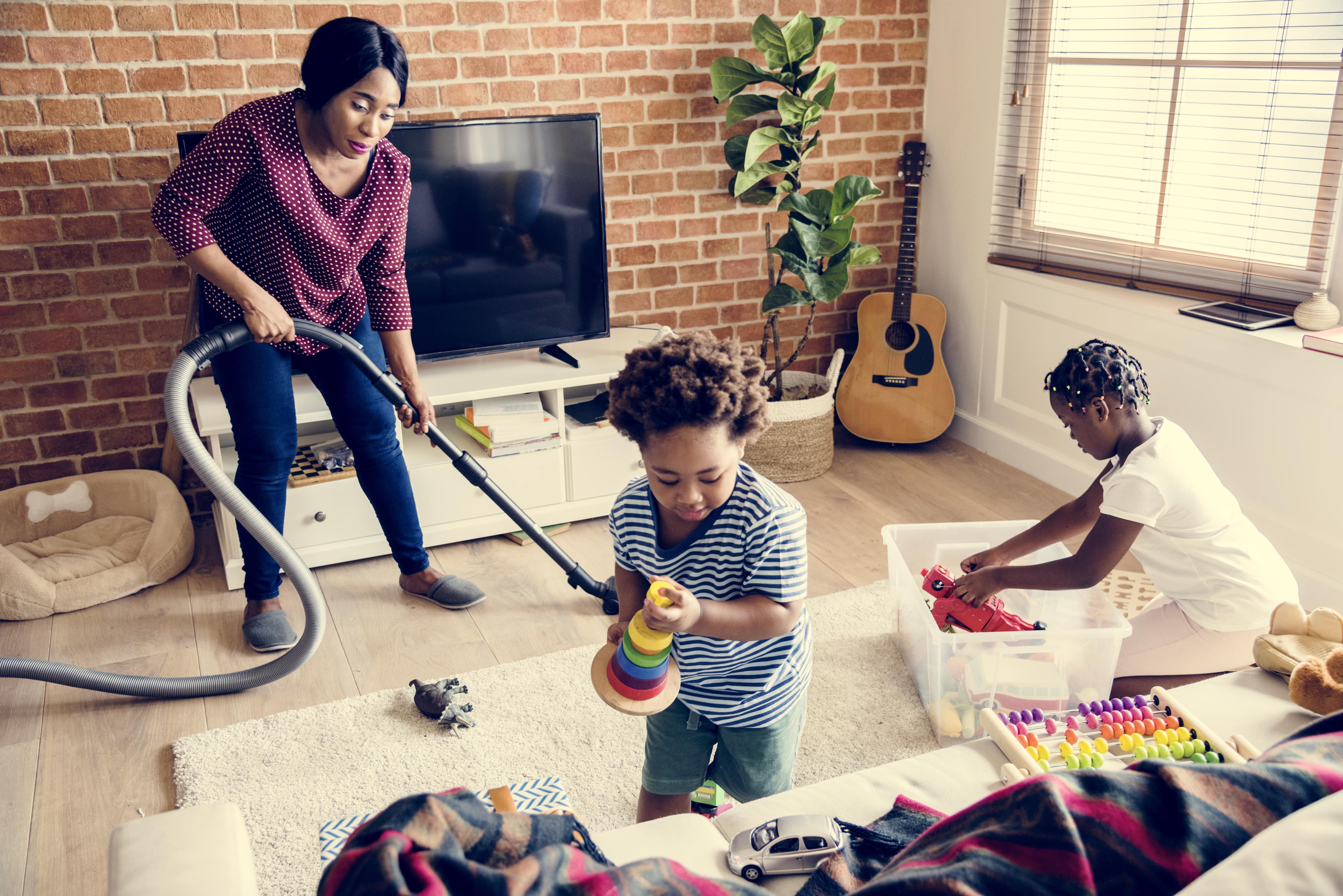A mother and her young children working together to clean their home. 