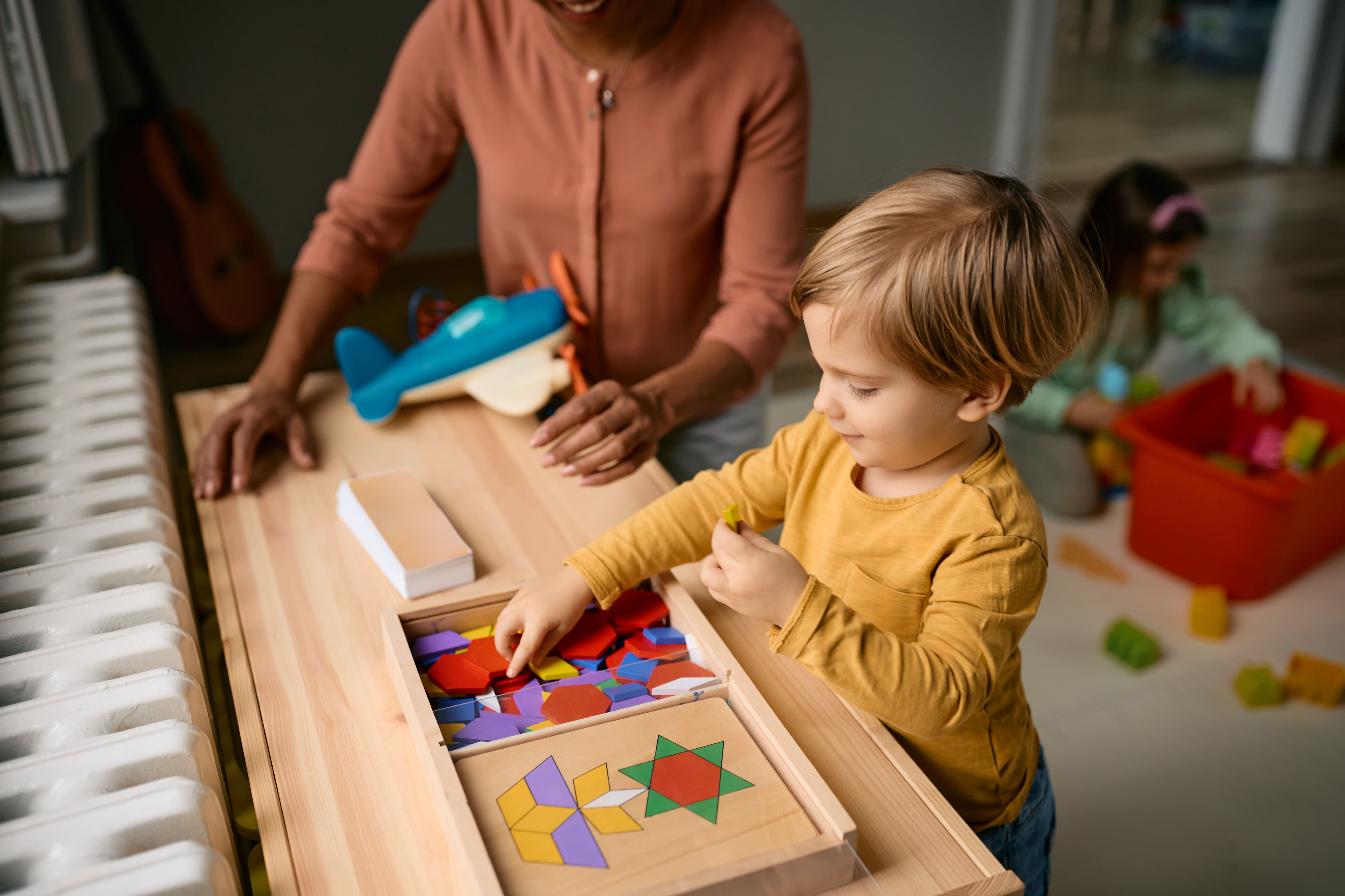 A young boy playing with his toys in his Montessori-inspired nursery. 